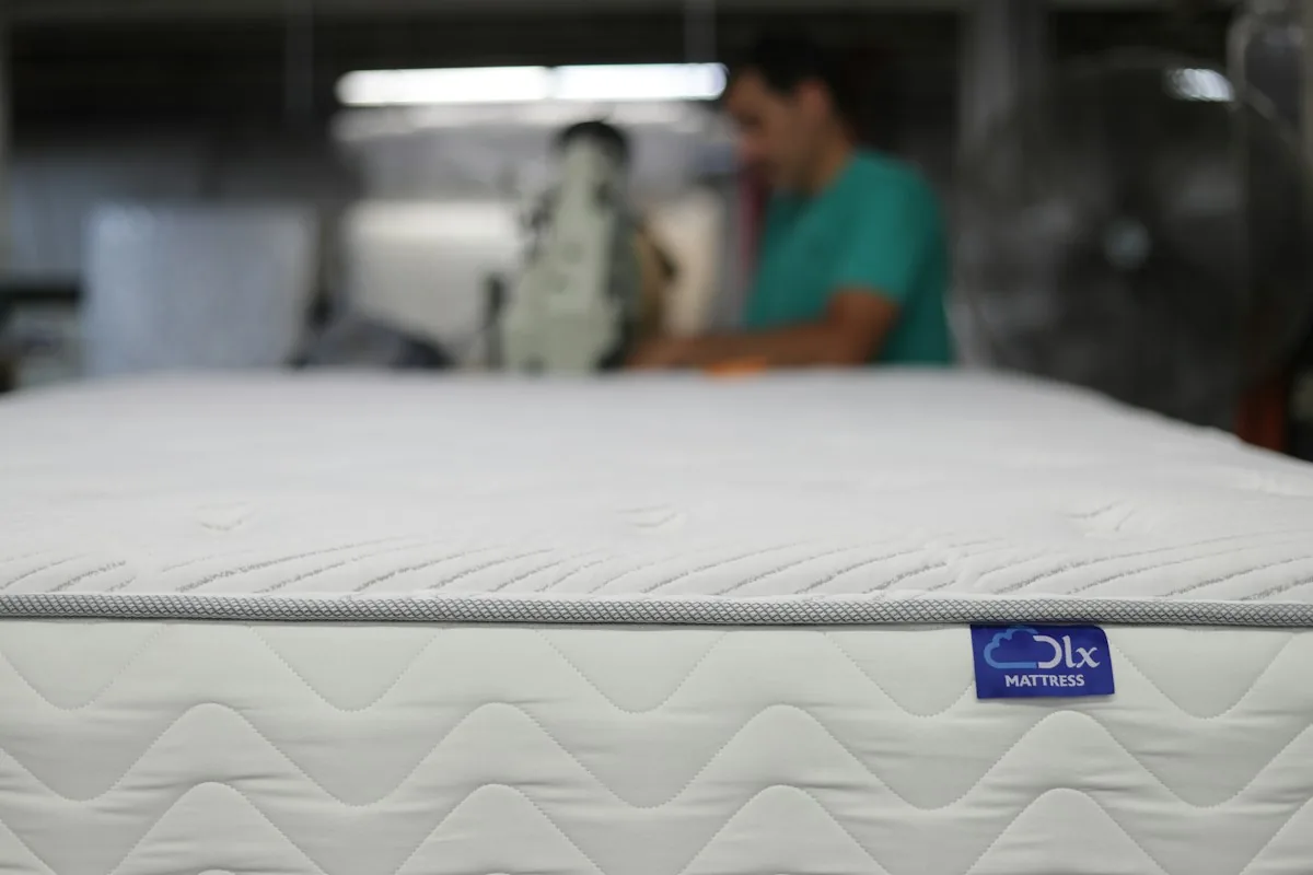 tepovanie matracov Trnava - a man is working on a mattress in a warehouse